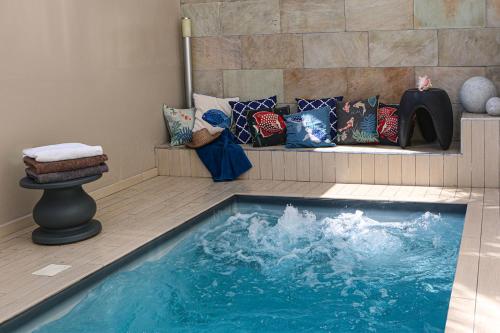 a pool of water in a room with pillows at Alyzes Diamant in Le Diamant