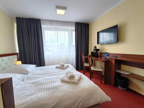 キェルツェにあるHotel SiLLのベッドとデスクが備わるホテルルームです。