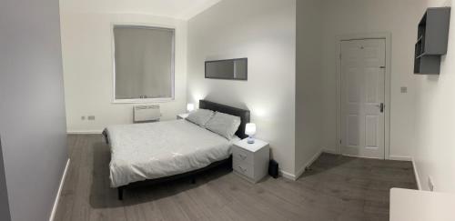 ein weißes Schlafzimmer mit einem Bett und einem Fenster in der Unterkunft Contractors House-Welcomes All in South Shields