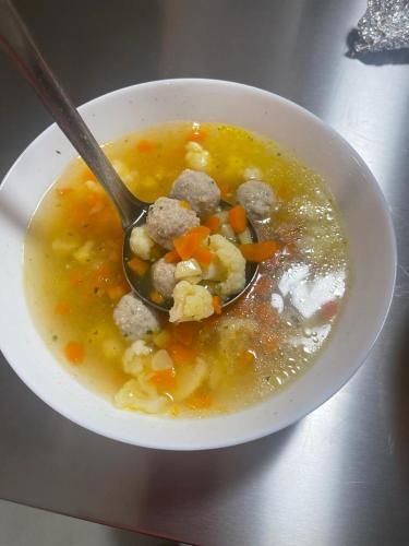 Una ciotola di zuppa con un cucchiaio dentro. di Bingyó Vendégház a Lupeni