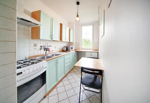 a kitchen with green cabinets and a table and a sink at Centrum - Smocza 20 in Warsaw