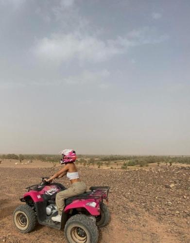 a person riding a pink atv in the desert at Bivouac ZAGORA in Zagora