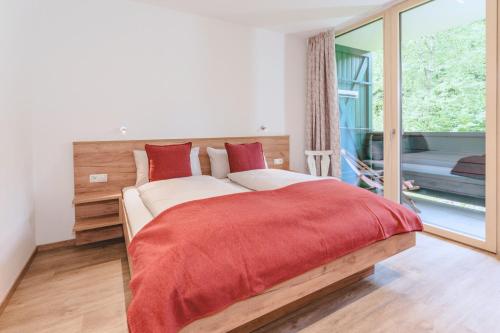 a bedroom with a large bed with a red blanket at ALPINE Appartement 208 Schladming by globboard in Schladming