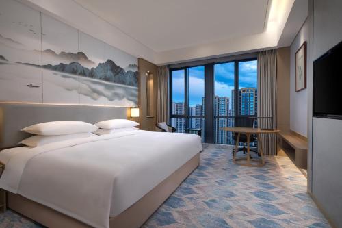 a hotel room with a large bed and a desk at Courtyard by Marriott Hangzhou Xiaoshan in Hangzhou