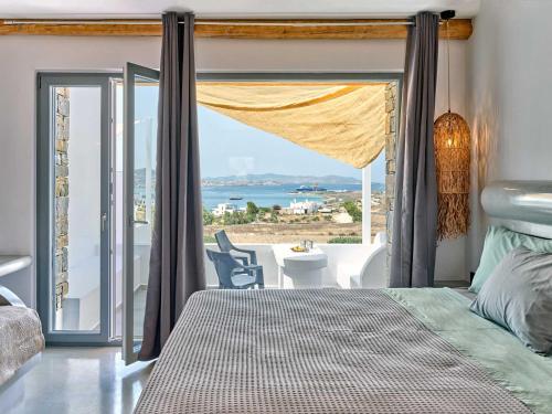 a bedroom with a bed and a view of the ocean at Ocean View Paros in Parikia