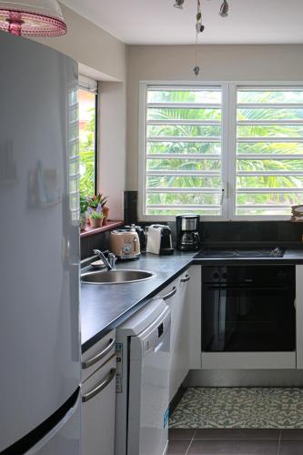 a kitchen with a sink and a stove top oven at Alyzes Diamant in Le Diamant