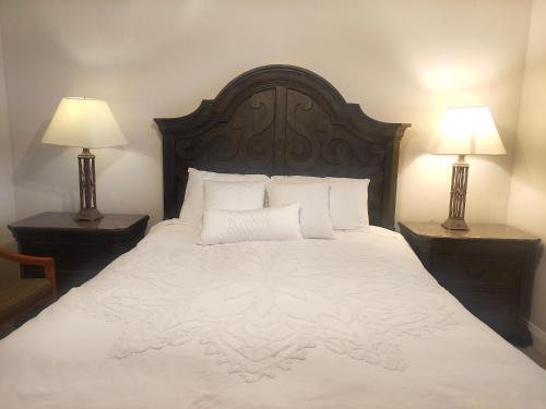 a bedroom with a large white bed with two lamps at Green Leaf B&B in West Kelowna