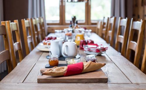 a long wooden table with a long table with food on it at Chalet Barragiste in Courchevel