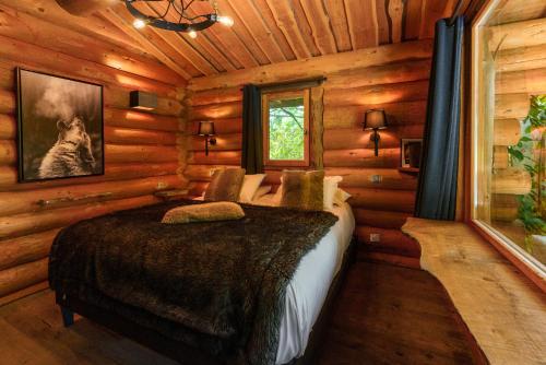 a bedroom with a bed in a log cabin at Pyrénées Prestige - Villas d'exceptions et hébergements insolites in Argelès-Gazost