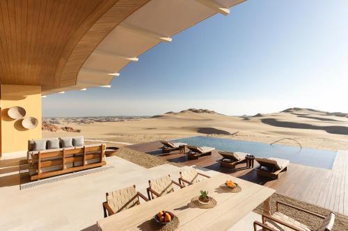 a house in the desert with a pool and chairs at Six Senses Southern Dunes, The Red Sea in Khuff