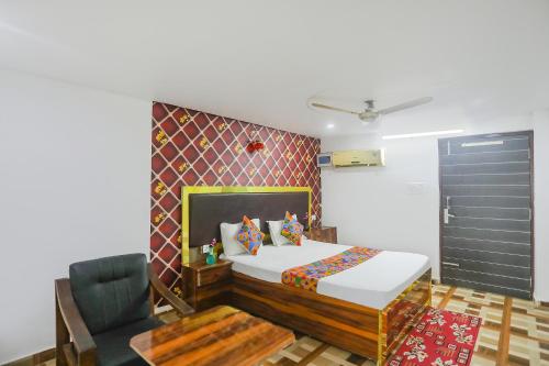 ein Schlafzimmer mit einem Bett, einem Stuhl und einer Tür in der Unterkunft FabExpress Umbrella in Patna