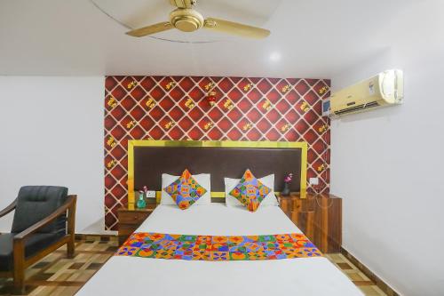 ein Schlafzimmer mit einem Bett und einem Stuhl in der Unterkunft FabExpress Umbrella in Patna