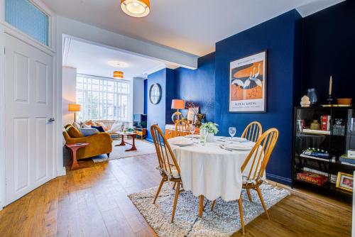 een eetkamer met een tafel en blauwe muren bij Pass the Keys Cosy house on the seafront in Southend-on-Sea