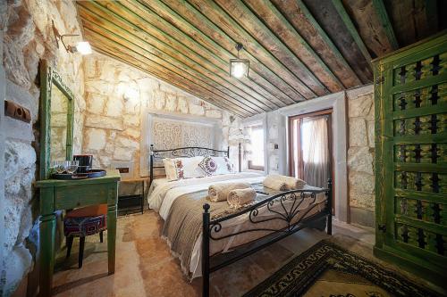 a bedroom with a bed and a stone wall at Aysel Inn House in Avcılar