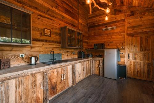 a kitchen with wooden cabinets and a refrigerator at Pyrénées Prestige - Villas d'exceptions et hébergements insolites in Argelès-Gazost