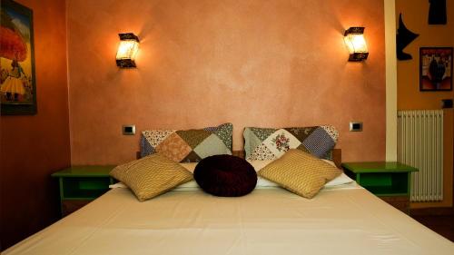 a bed in a room with two lights on the wall at Florivana Boutique Hotel in San Pietro in Cariano