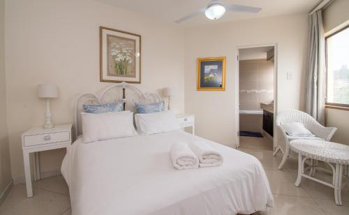 ein Schlafzimmer mit einem weißen Bett mit zwei Handtüchern darauf in der Unterkunft 31 Cormoran Umhlanga Rocks in Durban
