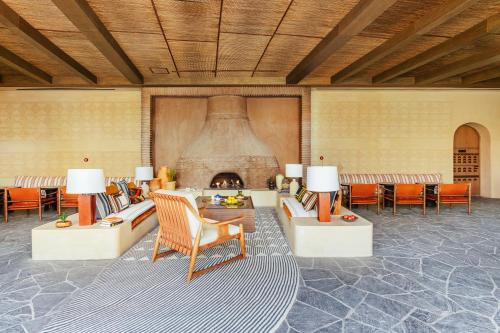 a living room with a fireplace and a couch and chairs at Six Senses Southern Dunes, The Red Sea in Khuff