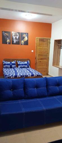 a blue couch in a room with a bed at RÉSIDENCE NGUARY in Dakar