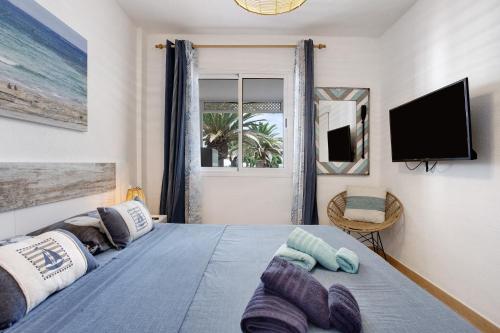 a bedroom with a bed with a tv on the wall at Casa Verdemar in Corralejo