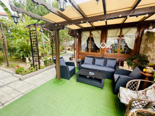 a patio with blue furniture and a pergola at Kastela Guest House in Chernomorets