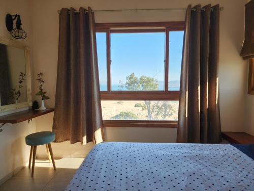 a bedroom with a bed and a large window at מול הכנרת Over looking the Sea of Galilee in Chorazim