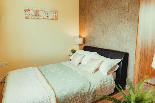 a bedroom with a bed with white sheets and pillows at Luxury Trearddur Bay beach house with sea views in Trearddur