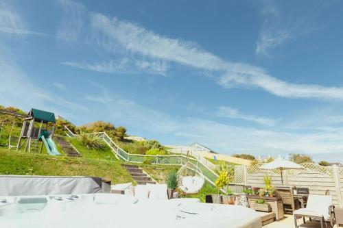 a set of stairs leading up to a playground at Luxury Trearddur Bay beach house with sea views in Trearddur