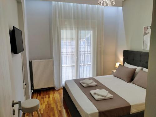 a bedroom with a bed with two towels on it at Εlite Αpartment Trikala in Tríkala