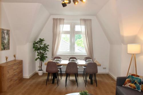 ein Esszimmer mit einem Tisch, Stühlen und einem Fenster in der Unterkunft Stilvolles Apartment im Zentrum in Zittau