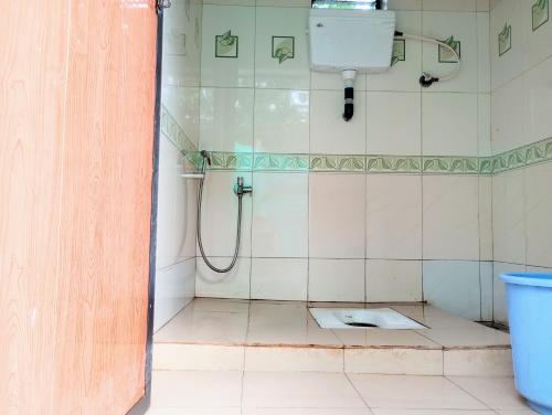 uma casa de banho com um chuveiro e um WC. em The Grace Guest House em Salcete
