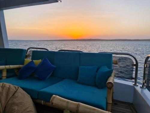 um sofá na parte de trás de um barco com um pôr-do-sol em VIP Yacht Diving Club em Sharm el Sheikh