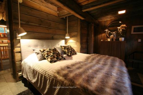 um quarto com uma cama grande e paredes de madeira em Holiday Home Aurora Cabin em Luosto