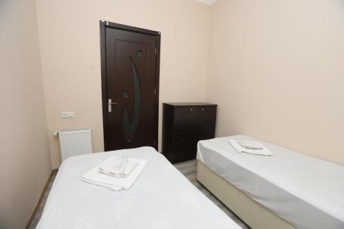 two beds in a room with a black door at The K Tbilisi in Tbilisi City