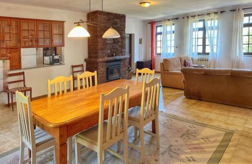 a kitchen and living room with a wooden table and chairs at Quinta Do Pereiro in Tábua