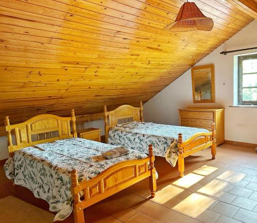 Duas camas num quarto com tecto em madeira em Quinta Do Pereiro em Tábua