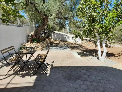a patio with two chairs and a tree at Olive tree cottage in Elia Laconias