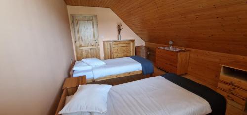 a bedroom with two beds in a wooden cabin at Chata Zemra in Nitrianske Rudno