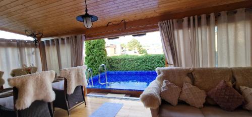 a living room with a couch and a swimming pool at Chata Zemra in Nitrianske Rudno