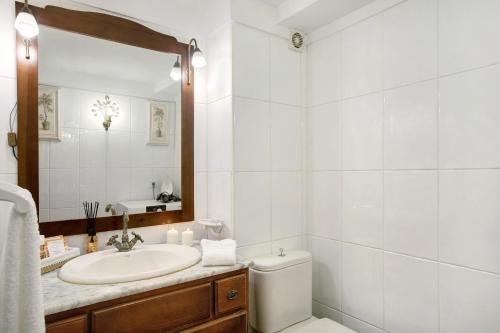 een badkamer met een wastafel, een toilet en een spiegel bij Apartamento Jardín del Sol in Tacoronte