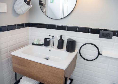 a bathroom with a sink and a mirror at Moncrivel Rooms & Relax in Benevello