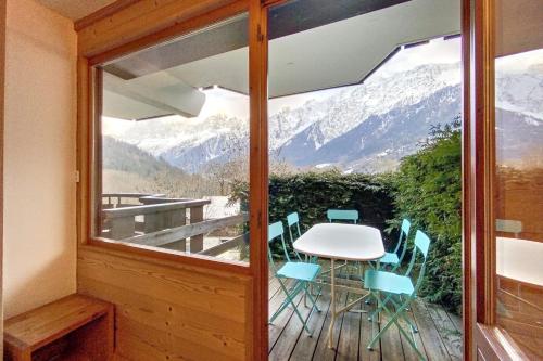 Habitación con balcón con mesa y sillas. en Rare pearl with incredible views, en Les Houches