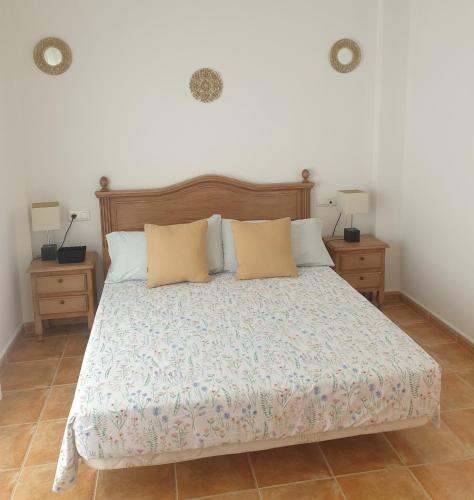 a bedroom with a bed with two night stands and two lamps at El Burré in Tolox