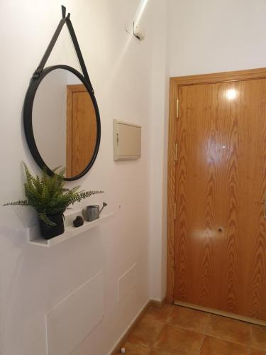 a hallway with a mirror and a wooden door at El Burré in Tolox