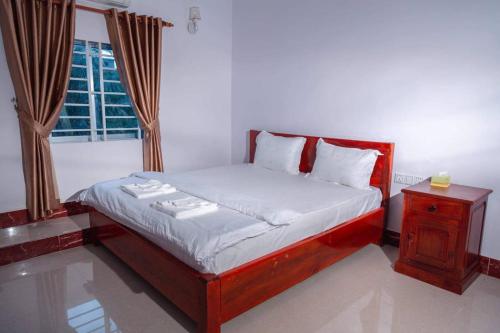 sypialnia z łóżkiem i oknem w obiekcie Kim Chua Guest House w mieście Kâmpôt