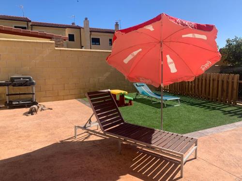 a chair and a red umbrella on a lawn at Chalet Pradonavas in Navas de San Antonio