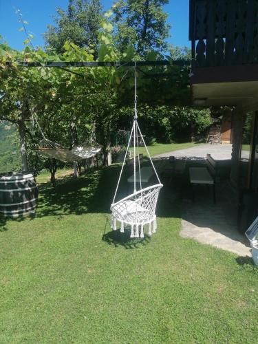 a swinging hammock in the yard of a house at Počitniška hiša 