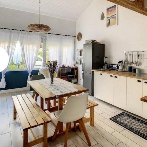 une cuisine avec une table et des chaises dans une pièce dans l'établissement La maison près du Lac, à Aureilhan