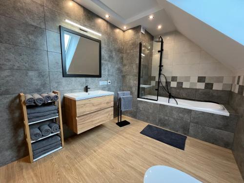 a bathroom with a sink and a tub and a mirror at Szczęśliwy Domek 