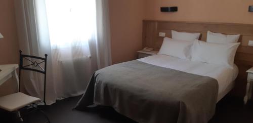 Ένα ή περισσότερα κρεβάτια σε δωμάτιο στο Hôtel des Roches - Climatisation